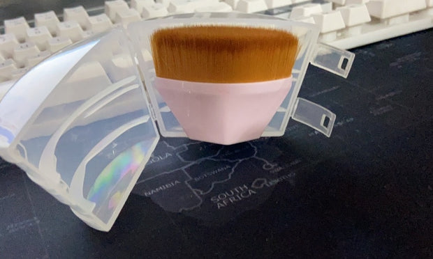Pink Magic Foundation Brush-Save Powder stored in a clear protective case, ideal for travel and hygienic storage.