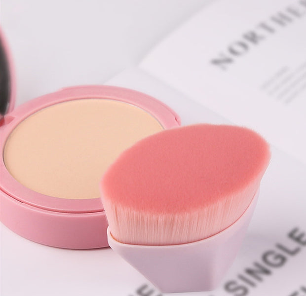 Close-up of pink Magic Foundation Brush-Save Powder with ultra-soft bristles, shown next to compact powder for smooth makeup finish.